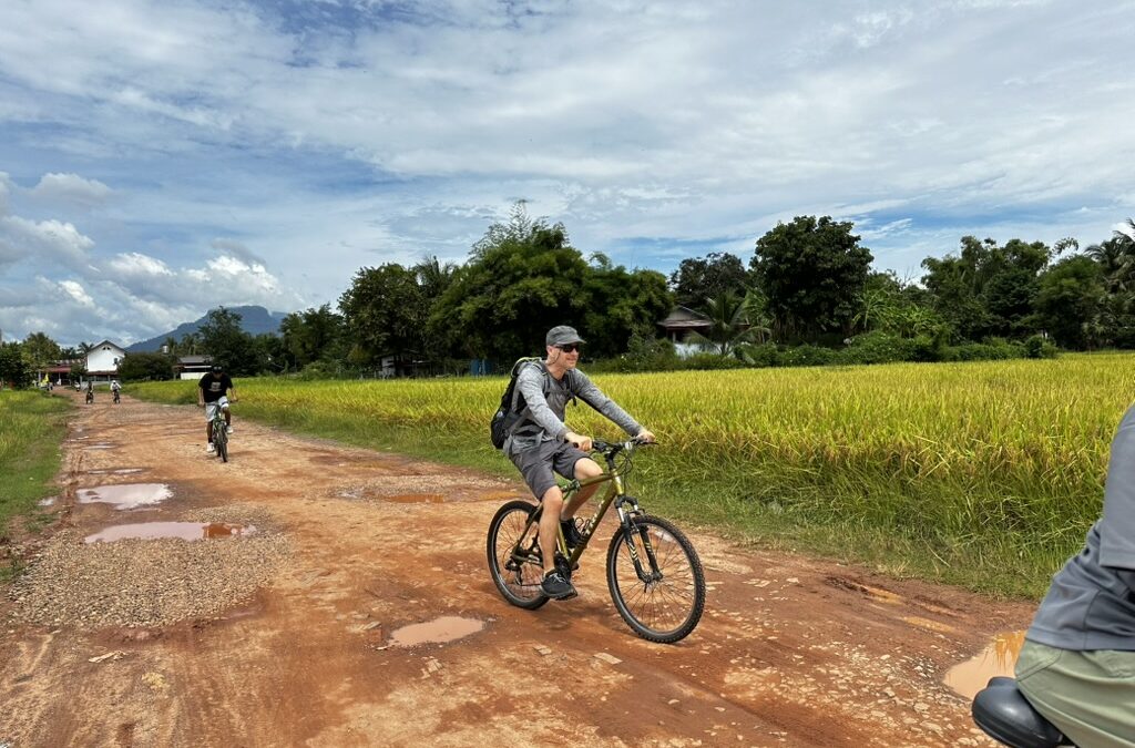 Cyclist on the laterite track of the ancient Khmer road, Champasak, southern Laos