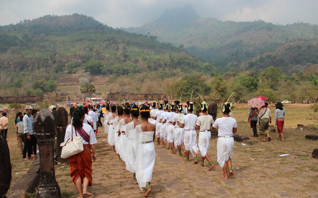 Procession de danseuses en blanc sur l'allée du Vat Phou pendant la fête de Boun Vat Phou, le Phou Khao au fond